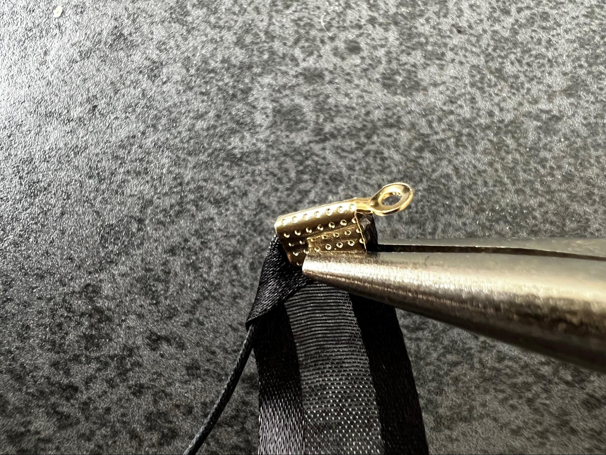 ヤットコで金具を留めている様子